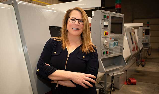Gina Caronna standing in front of machinery