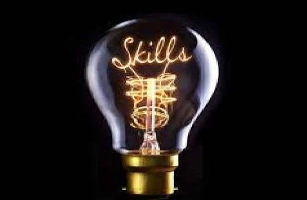 Skills Based Hiring article. Pic of a lightbulb showing the filament spelling out the work Skills. Black background.