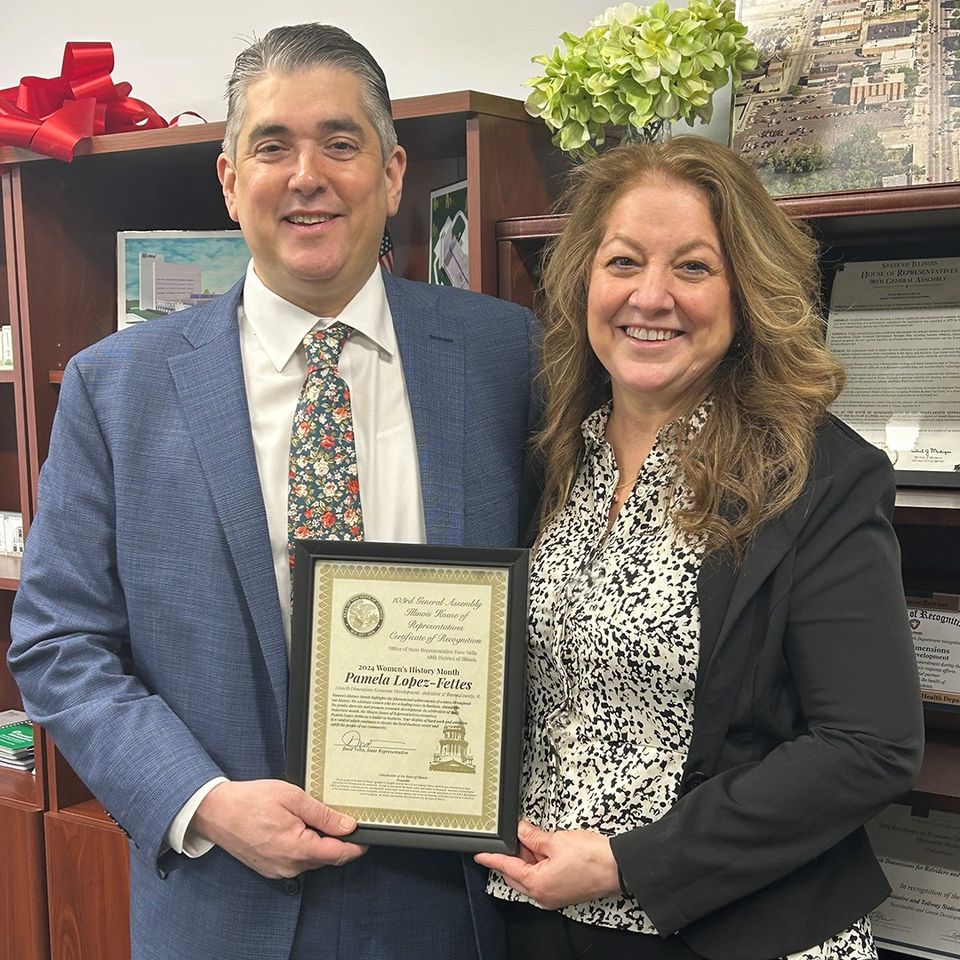 Photo is of Board Member, Pamela Lopez-Fettes, standing with Dave Vella holding a recognition award.